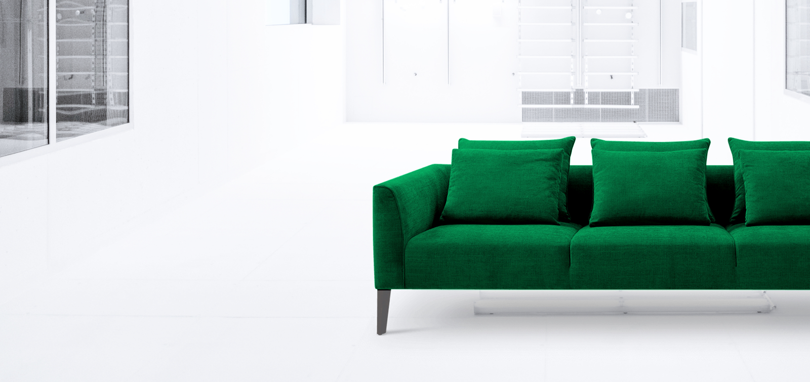 Three-seater green couch with cushions on steel legs.